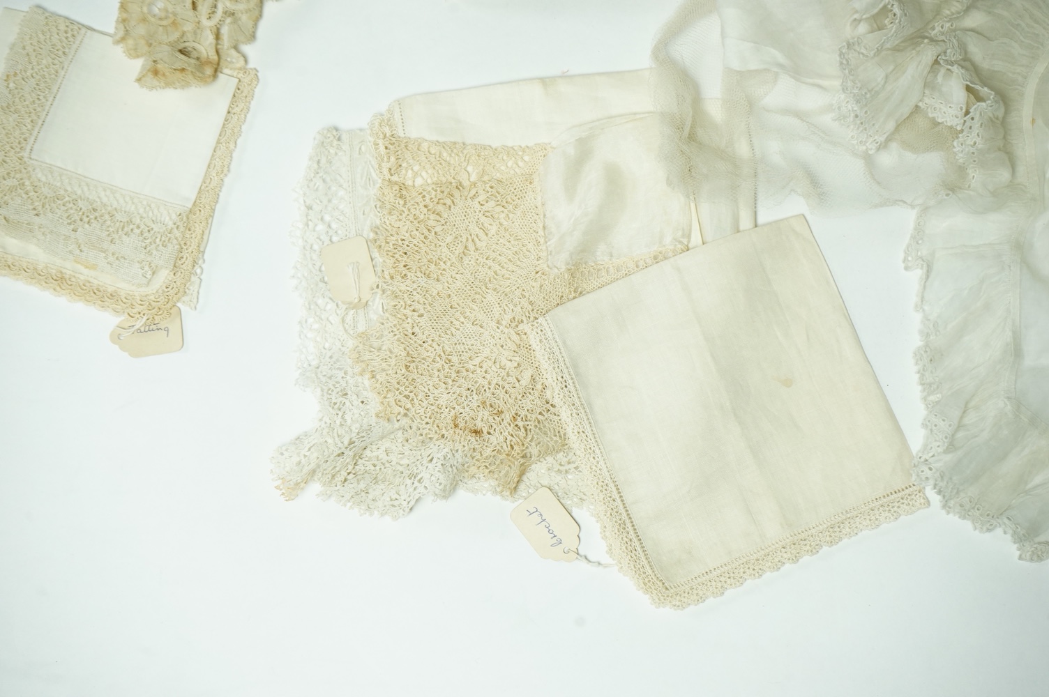 A Honiton lace wedding veil, (that has been cut into pieces), a Honiton edged collar, white worked jabot, various lace hankies etc. condition variable, very useful for theatre and film costume dramas.